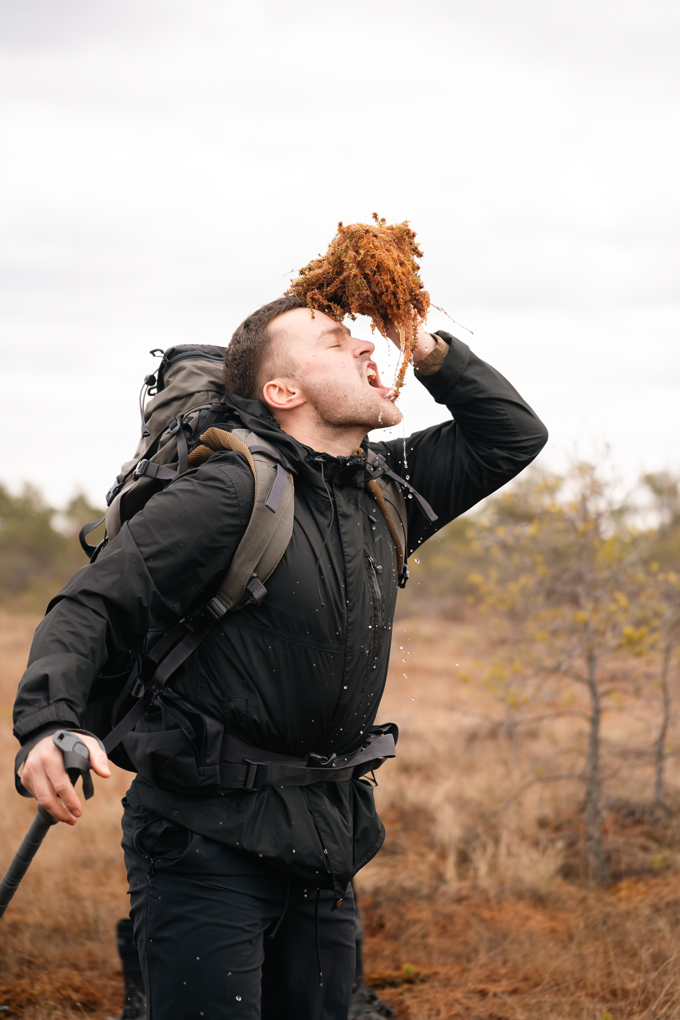 Eriks Zirnis drinking moss-filtered water while hiking